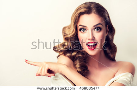 https://thumb7.shutterstock.com/display_pic_with_logo/1054231/469085477/stock-photo-woman-surprise-showing-product-beautiful-girl-with-curly-hair-pointing-to-the-side-presenting-469085477.jpg
